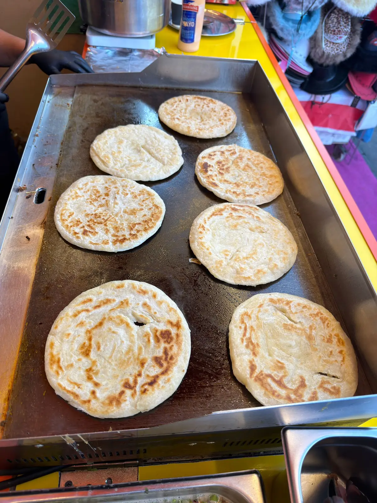 Fresh parathas cooking on the griddle